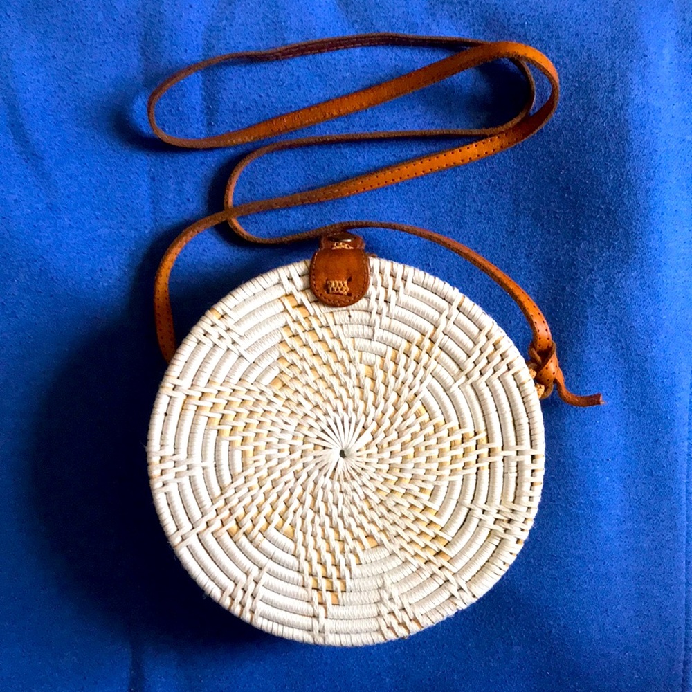 White, round bamboo and nylon weaved pocketbook w/a single snap closure on top.